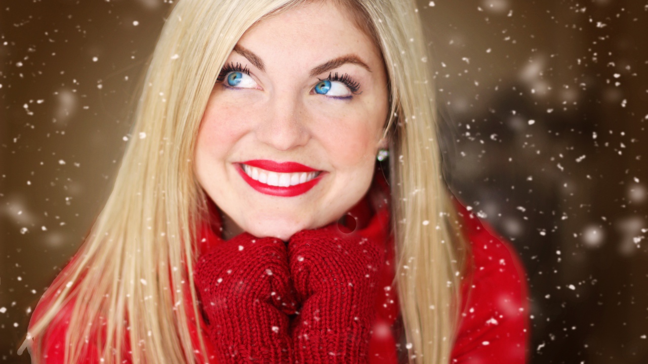 Улыбающаяся голубоглазая девушка в красном свитере 