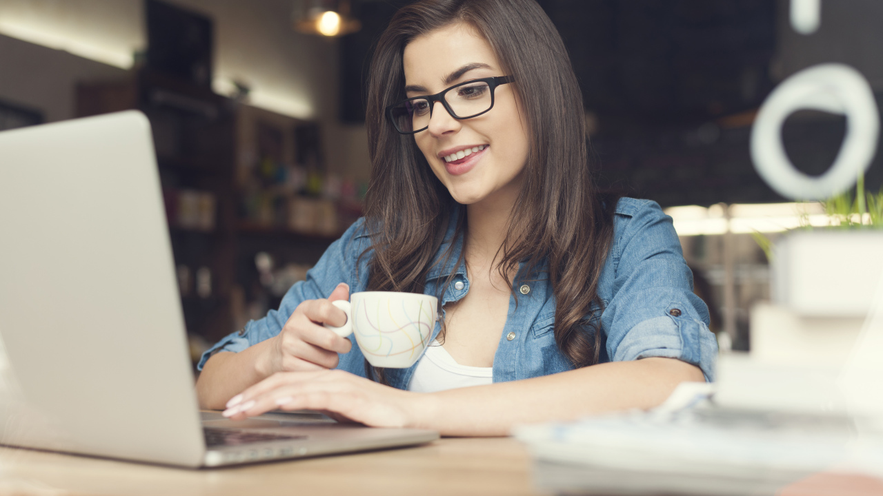 Улыбающаяся девушка в очках с ноутбуком