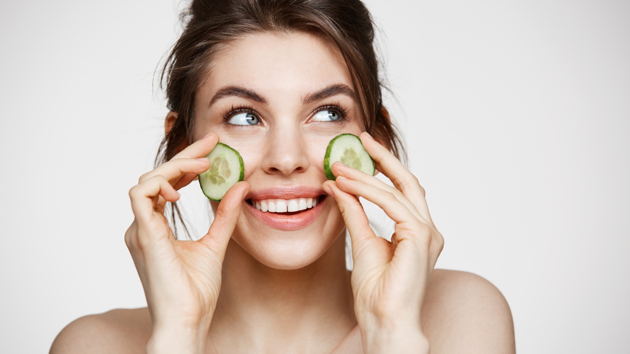 Улыбающаяся девушка с огурцами на лице