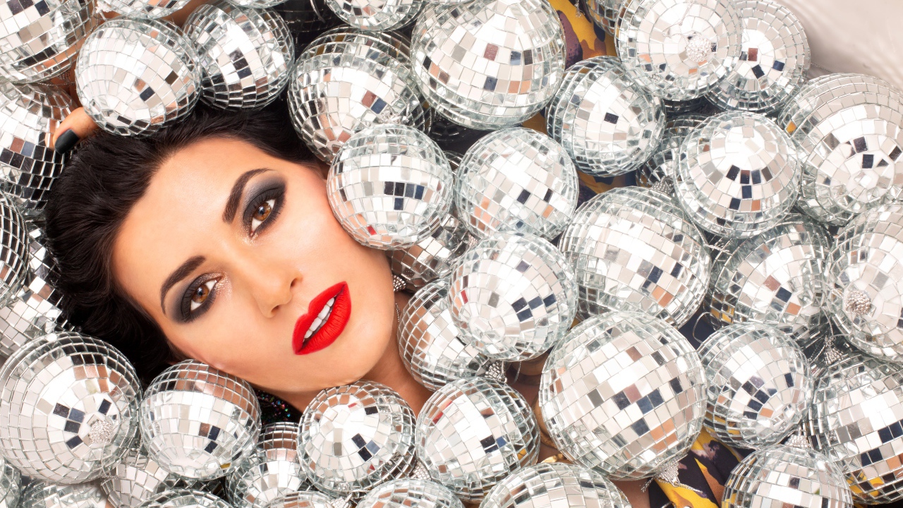 Молодая девушка усыпана блестящими шарами