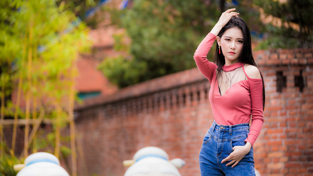 Молодая стройная азиатка в джинсах 