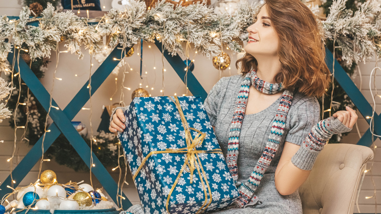 Красивая девушка с большим подарком на Рождество