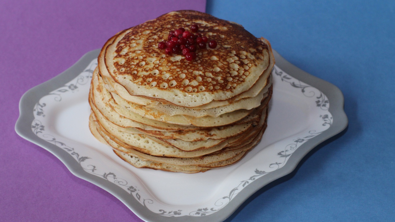 Румяные блины с ягодами на столе на Масленицу