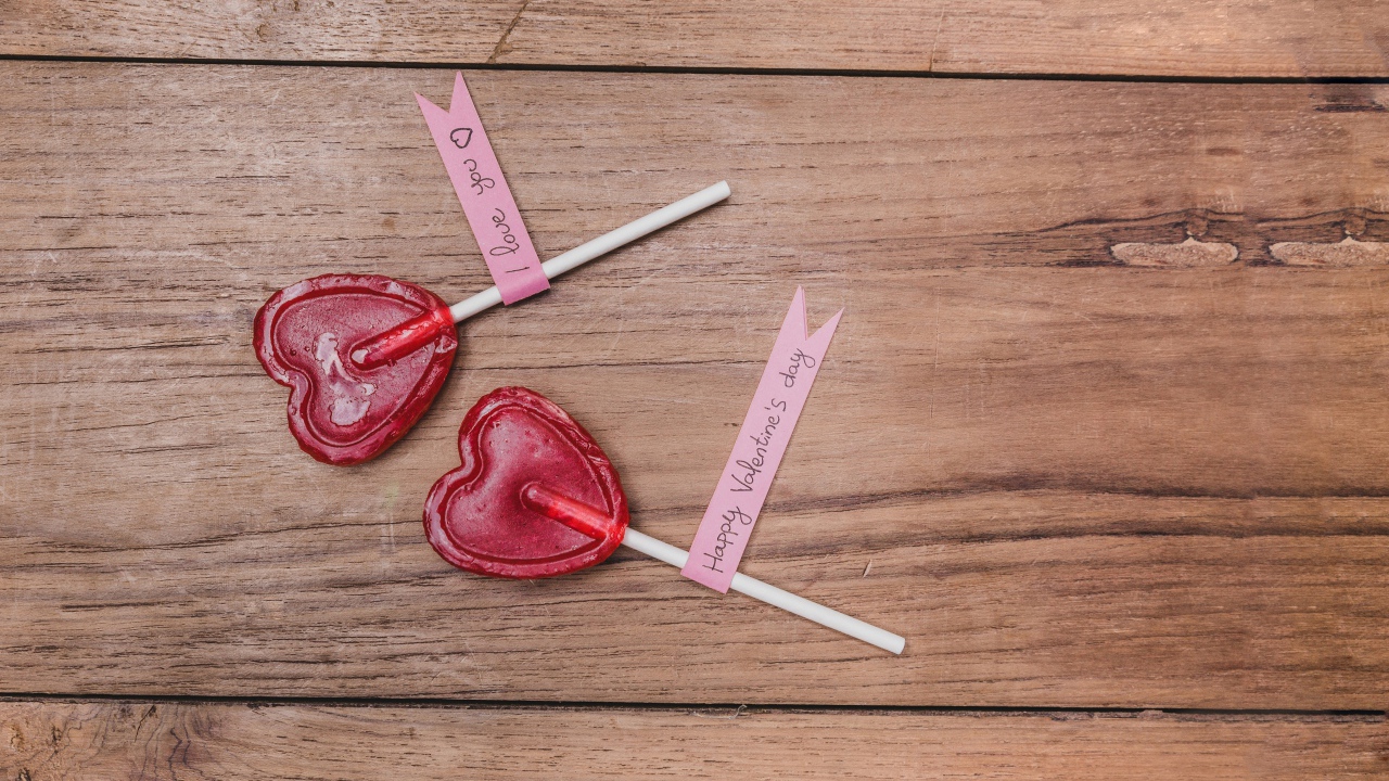 Два красных леденца для любимой на деревянном столе