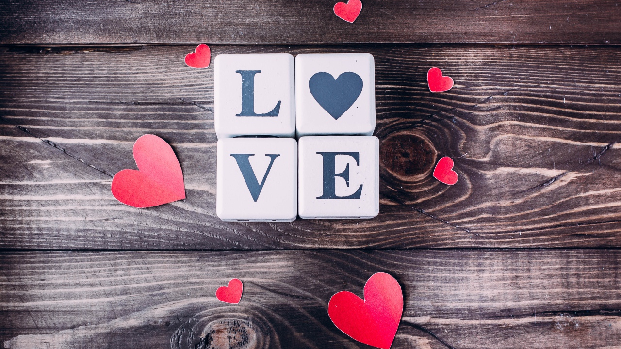 Кубики  с надписью любовь с сердечками на деревянном столе