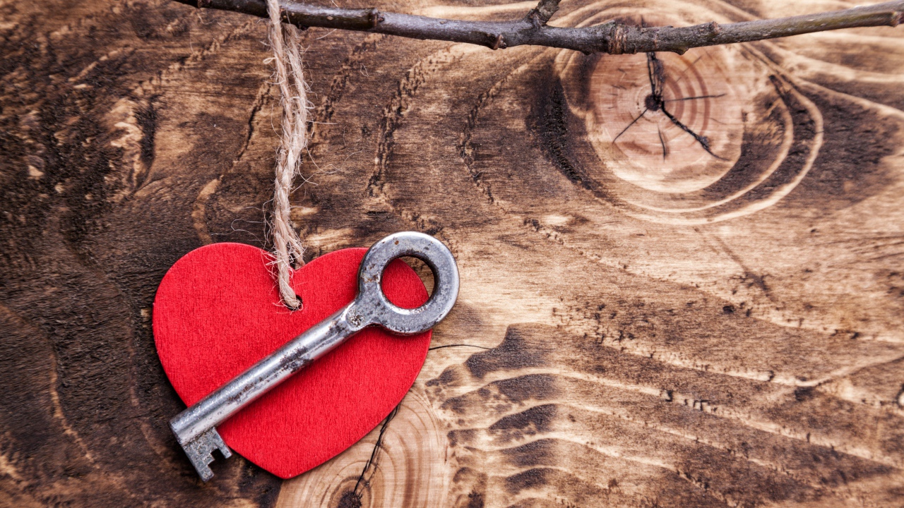 Красное сердечко и ключ на деревянном столе
