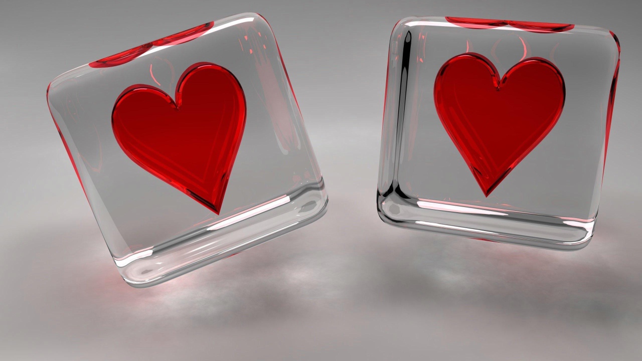 Два стеклянных кубика с сердечками на сером фоне