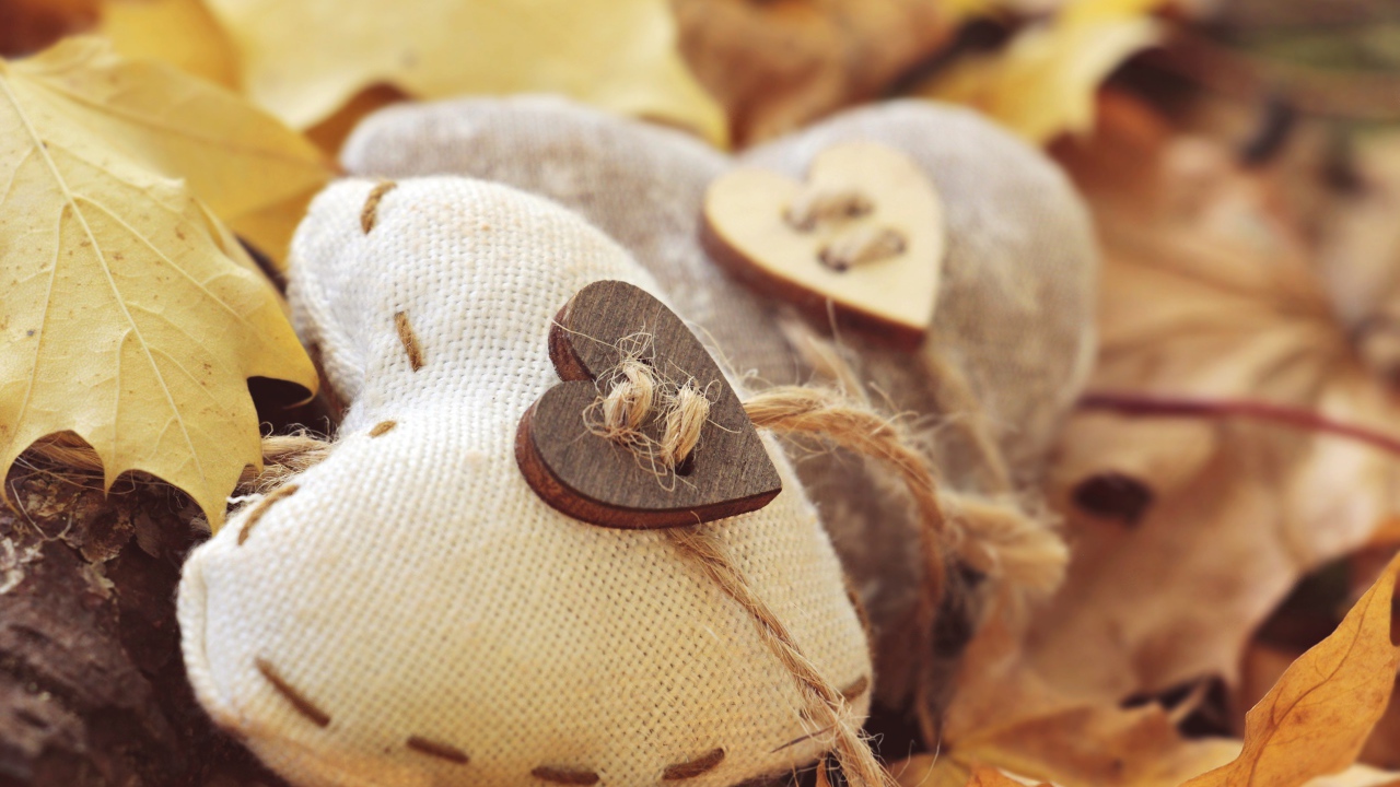 Два сердца из ткани лежит на земле с листьями 