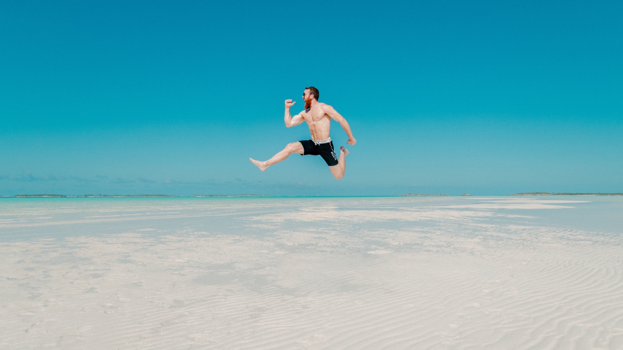 Довольный мужчина прыгает в воде на голубом фоне 
