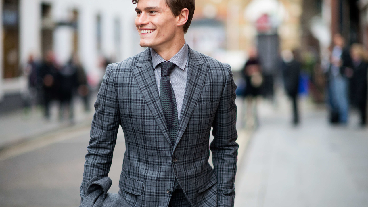 Улыбающийся молодой мужчина в костюме 