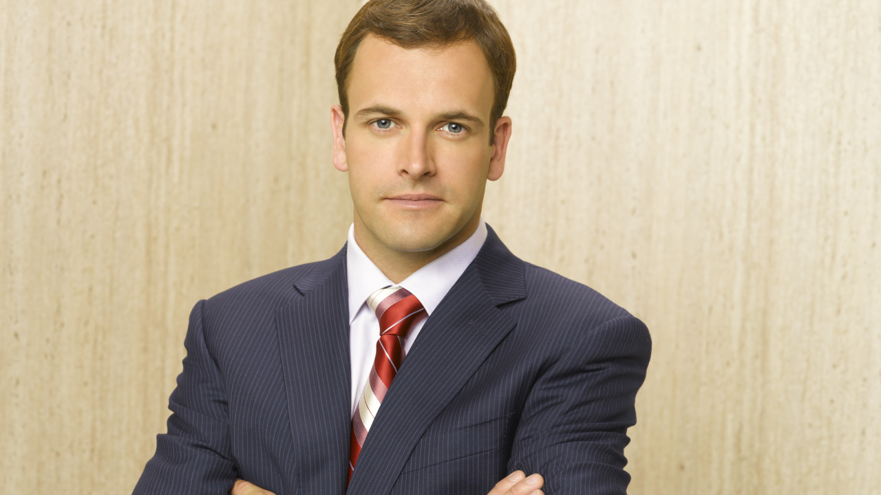 Актер Джонни Ли Миллер в костюме у стены