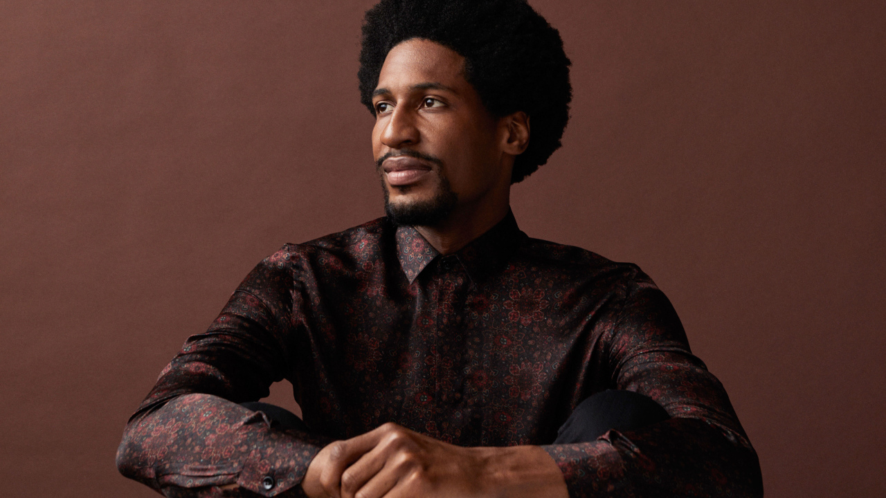 Музыкант Джонатан Батисте на коричневом фоне