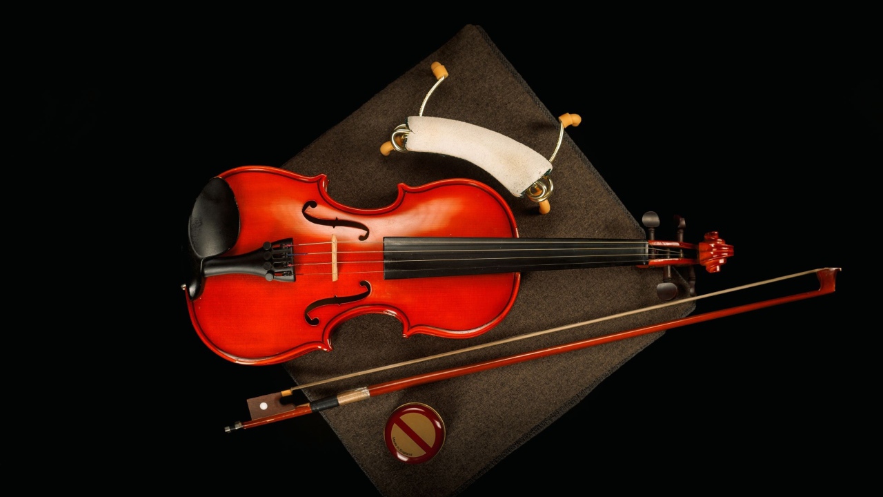 Красная скрипка со смычком на черном фоне
