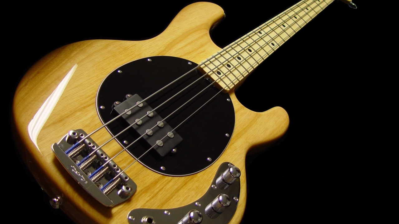 Деревянная гитара с толстыми струнами на черном фоне 