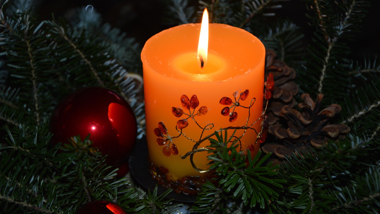 Зажженная свеча с ветками ели 