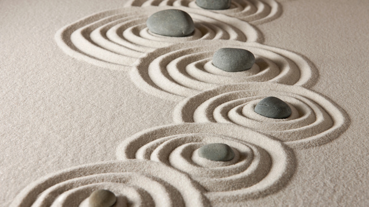 Маленькие серые камни с кругами на песке 