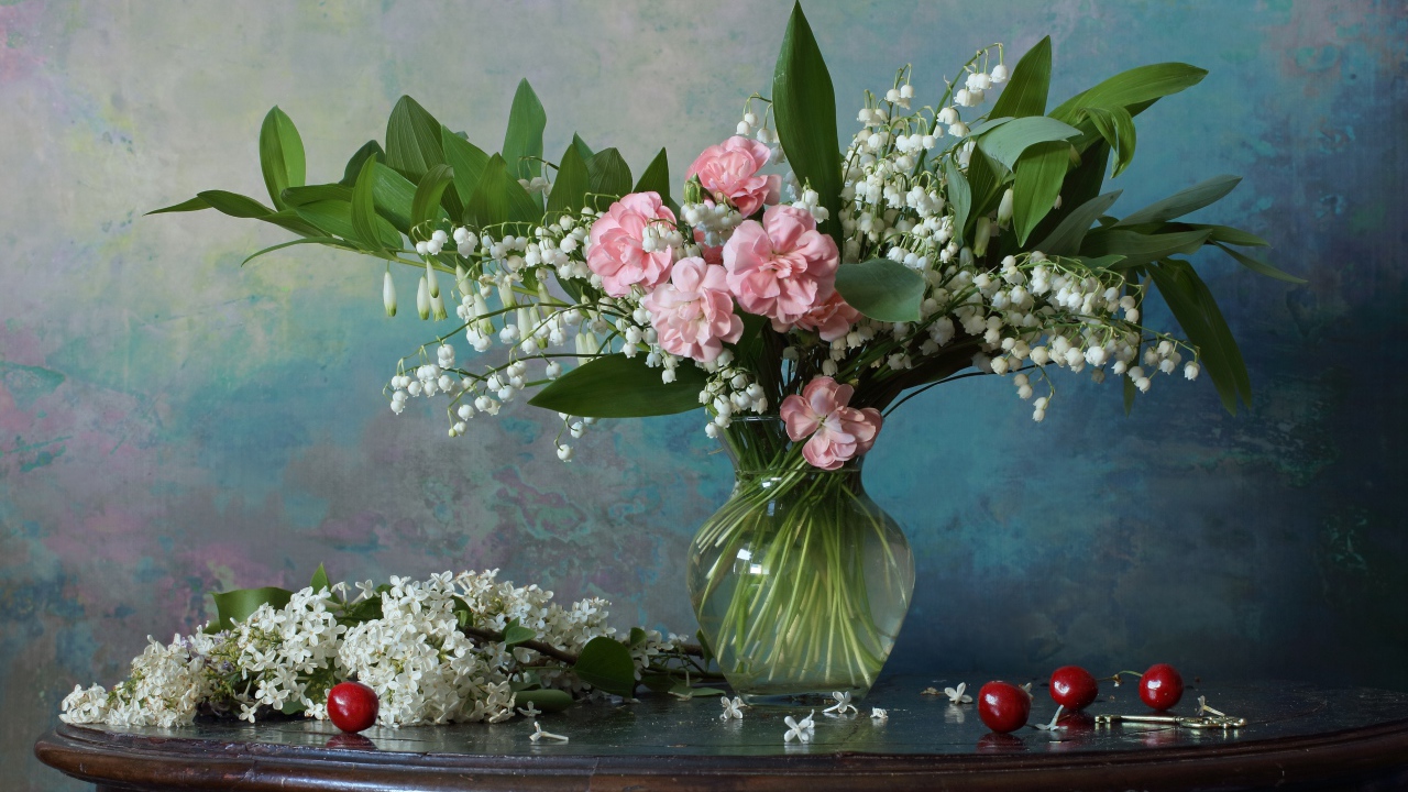 Красивый букет ландышей с розовыми цветами на столе с веткой сирени 