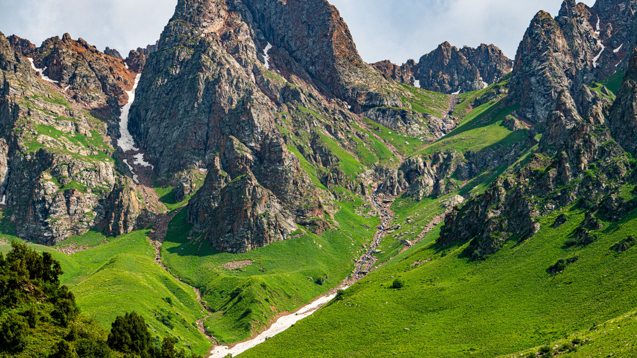 Большие каменные горы с зеленым ковром травы