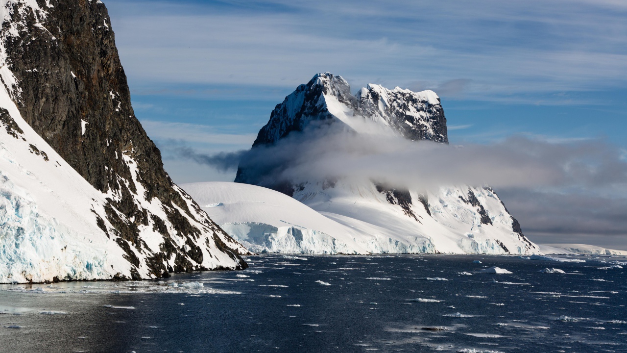 Заснеженные горы у покрытого льдом океана 