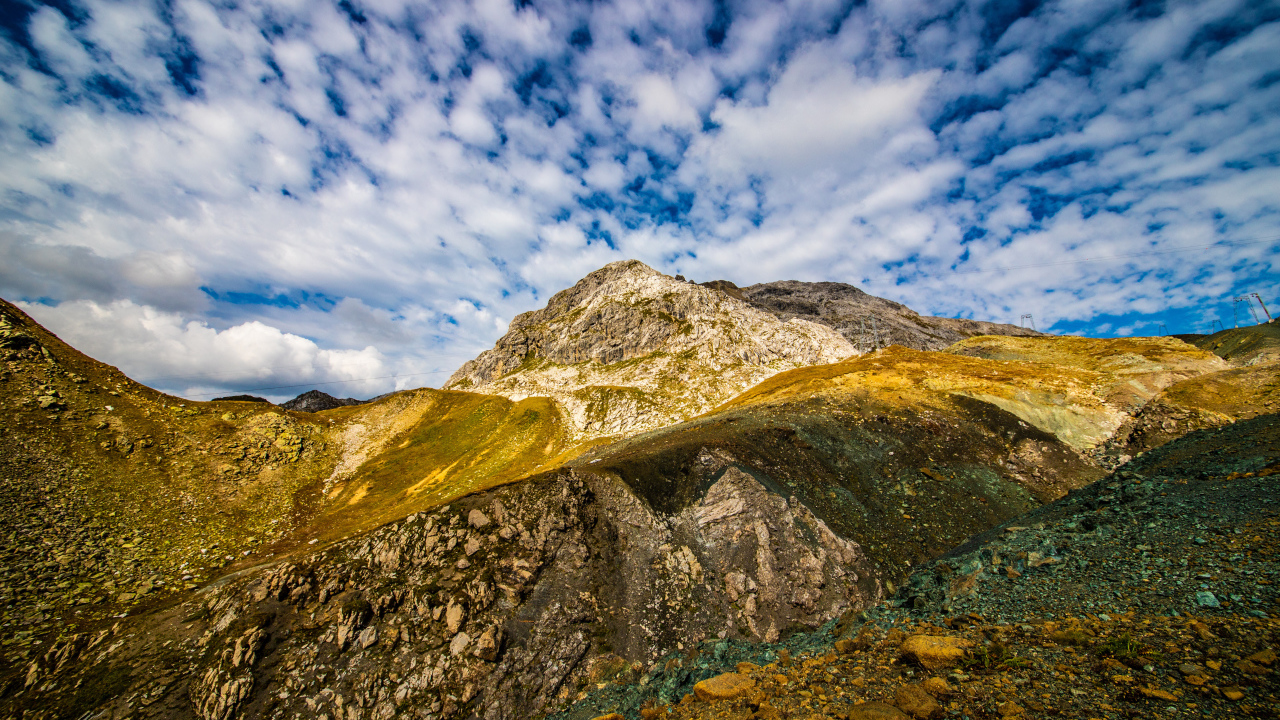 Швейцарские Альпы под голубым небом с белыми облаками