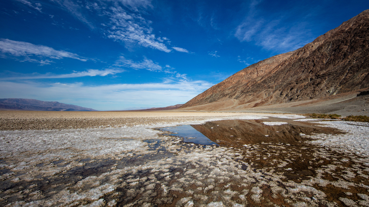 Соленая земля у горы под голубым небом