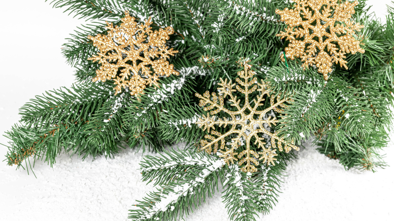 Золотистые снежинки и еловые ветки на снегу