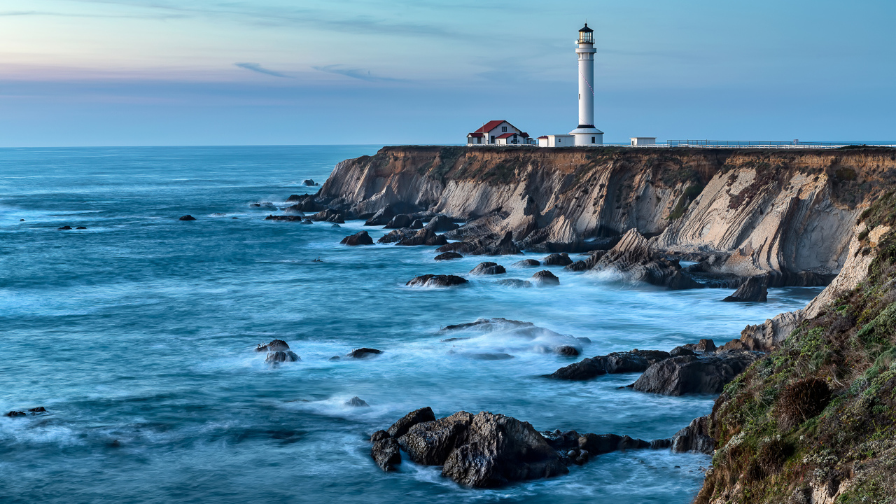 Маяк на берегу моря на краю утеса 