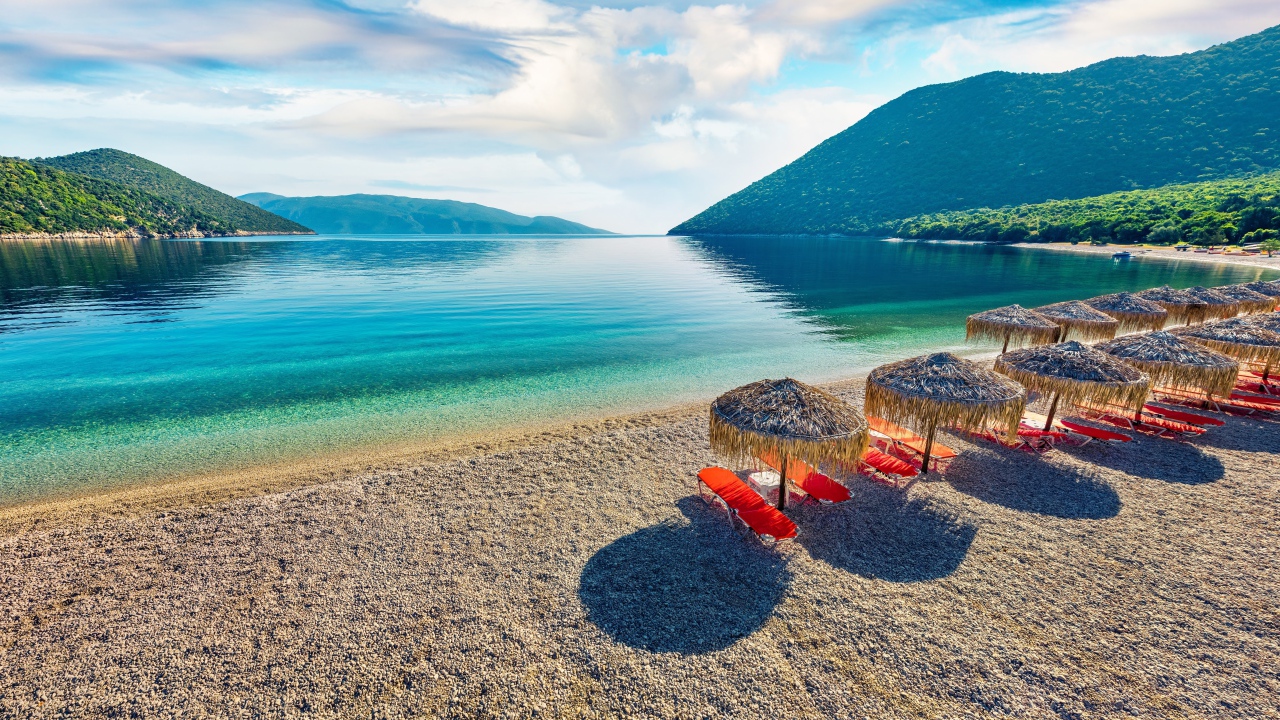 Шезлонги стоят на берегу озера у гор 