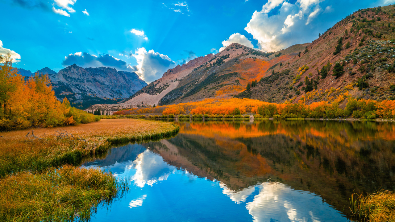 Красивый осенний горный пейзаж под голубым небом у  озера