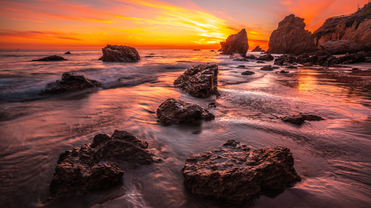 Красивый закат солнца на берегу моря с камнями 