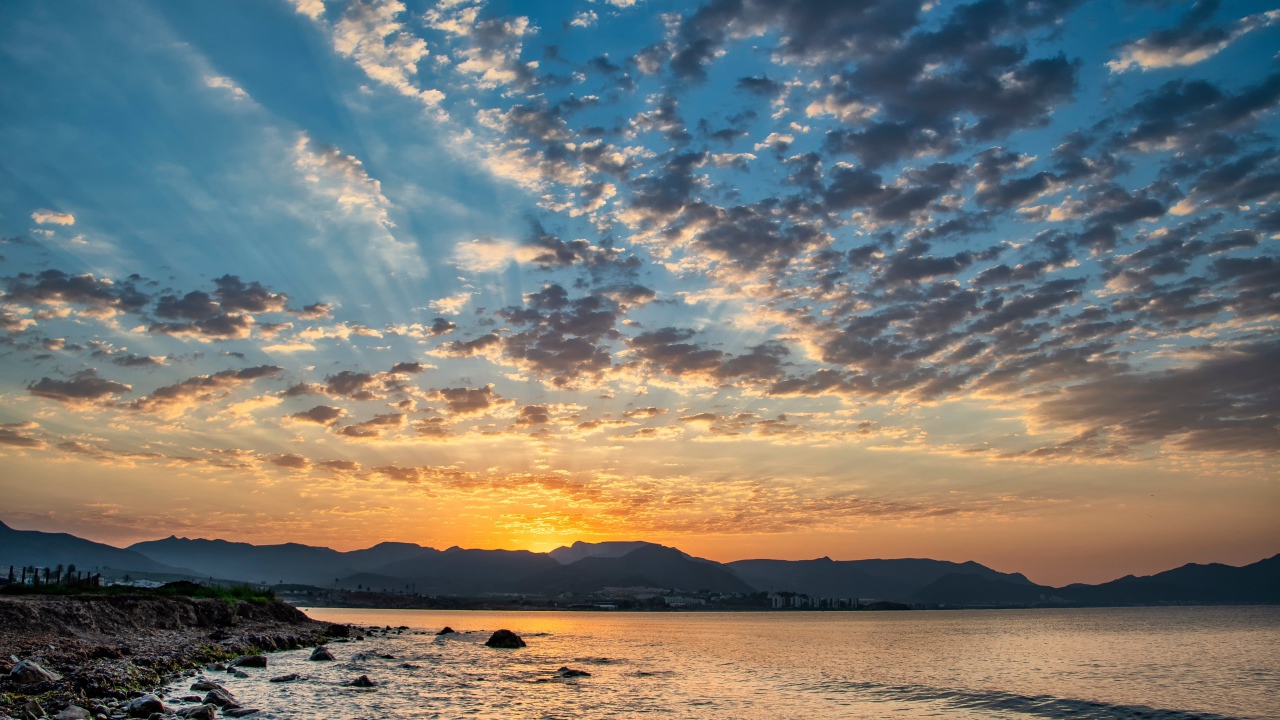 Рассвет солнца за горой у озера 