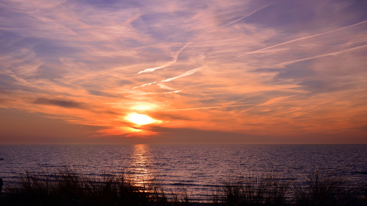 Закат солнца над спокойным озером летом