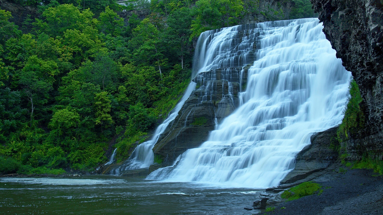 Красивый каскадный водопад с зелеными деревьями
