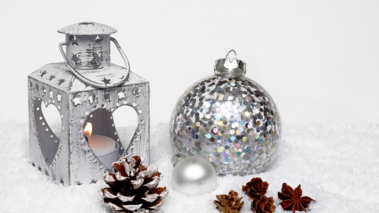 Фонарик и елочный шар с шишками на снегу