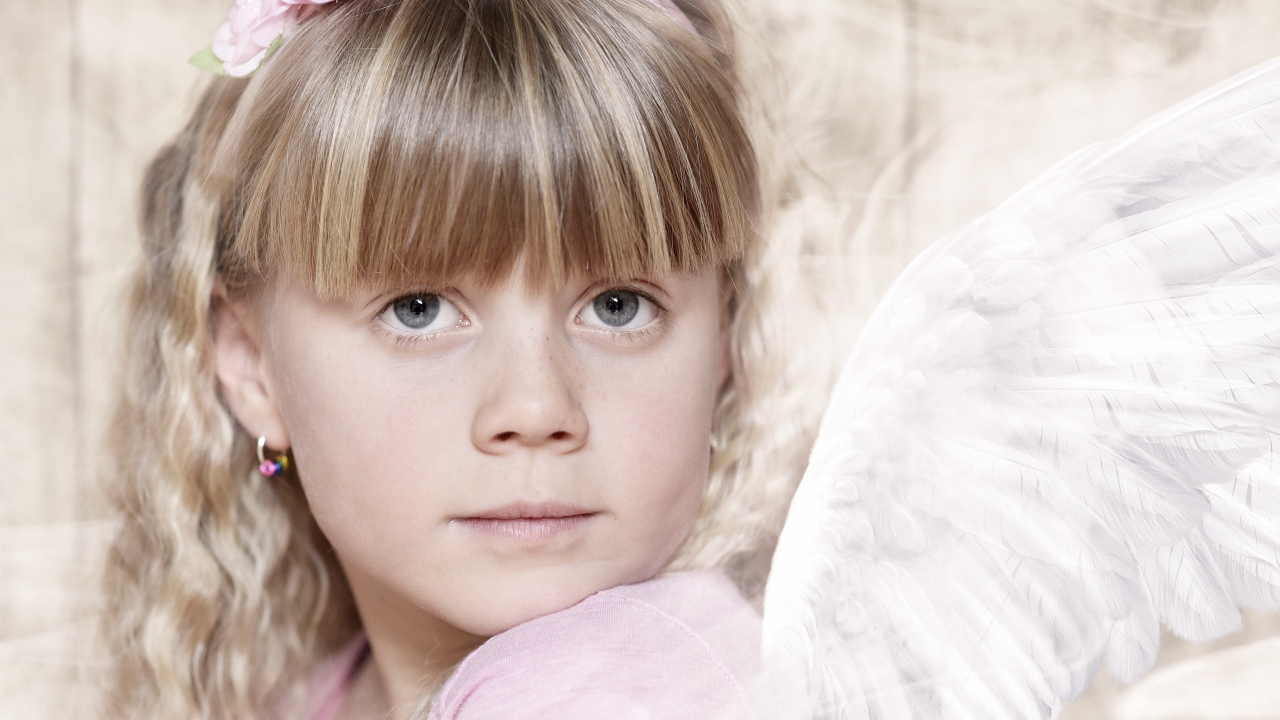 Красивая девочка с крыльями ангела с украшением на голове 