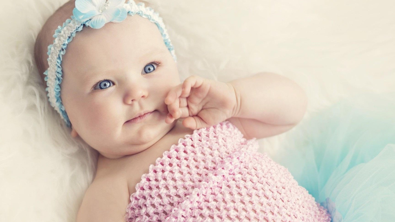 Голубоглазая маленькая девочка с повязкой на голове 