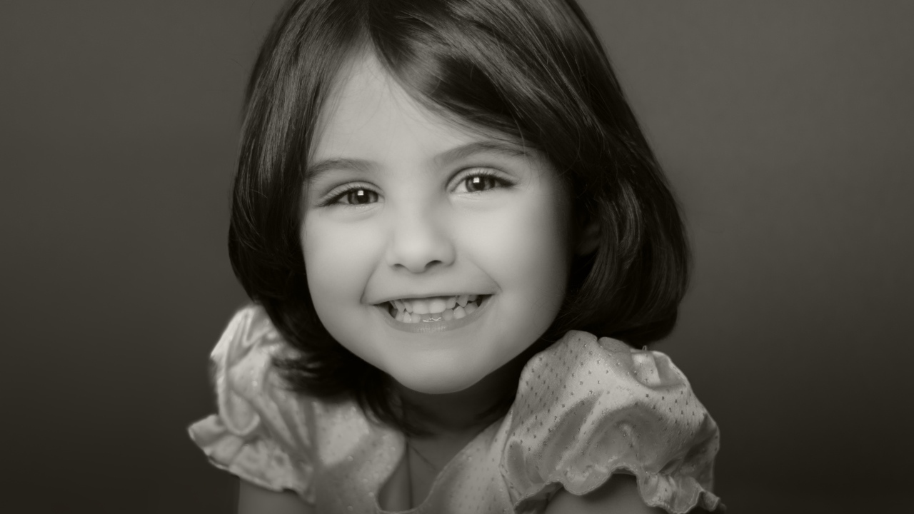 Милая улыбающаяся маленькая девочка черно-белое фото