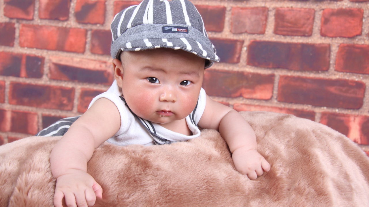 Маленький азиатский ребенок на фоне стены