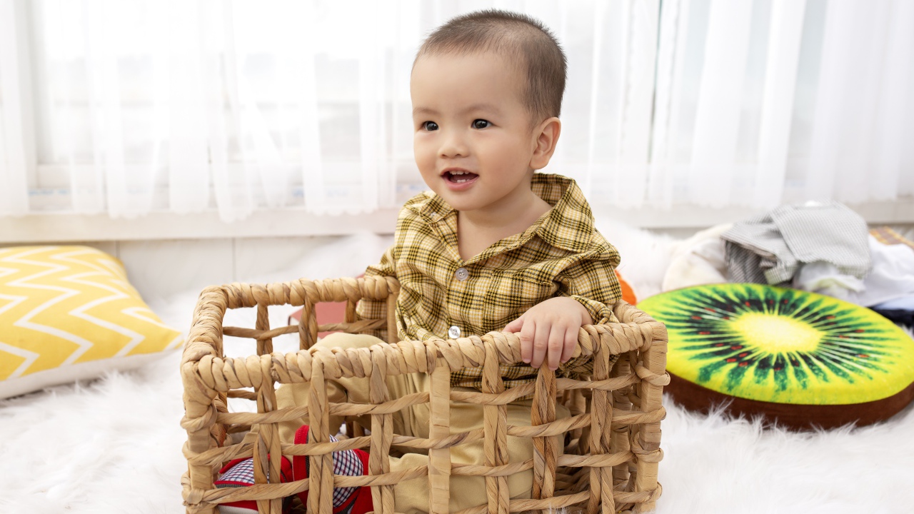 Маленький мальчик сидит в ящике в игровой комнате