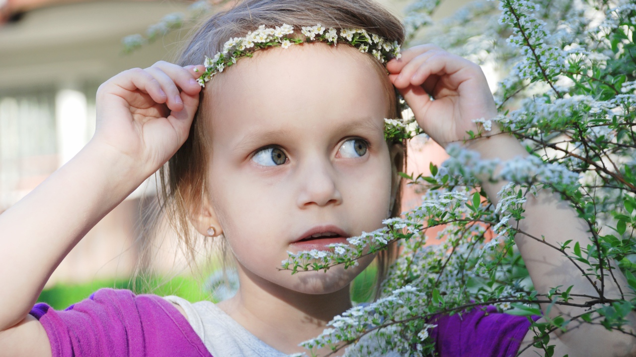 Маленькая девочка украсила голову белым цветком 