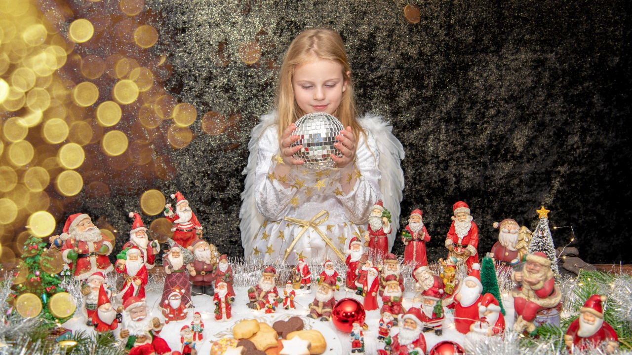 Маленькая девочка в костюме ангела с новогодним декором