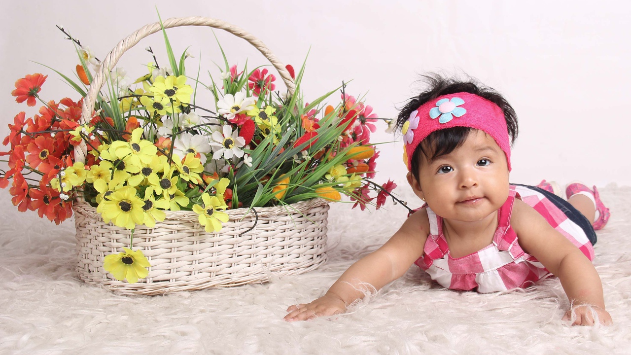 Маленькая девочка рядом с корзиной цветов 