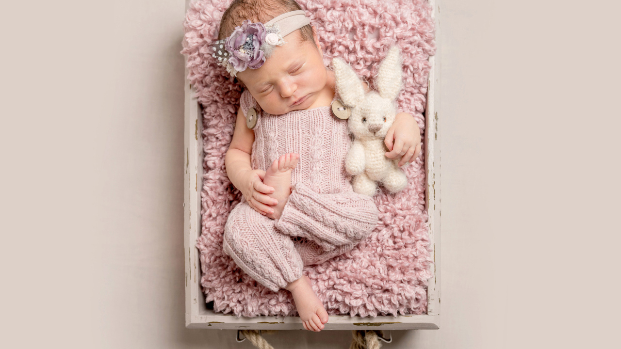 Маленькая новорожденная девочка спит в ящике 