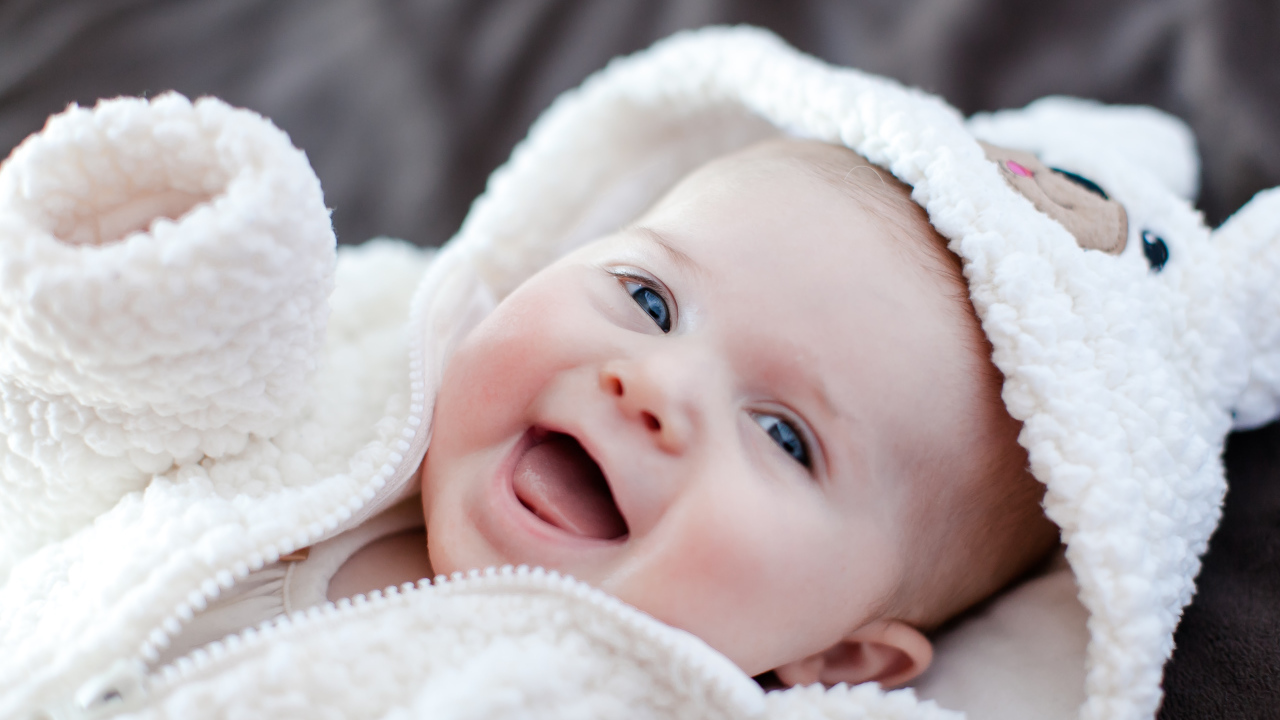 Улыбающийся милый ребенок в теплом костюме 