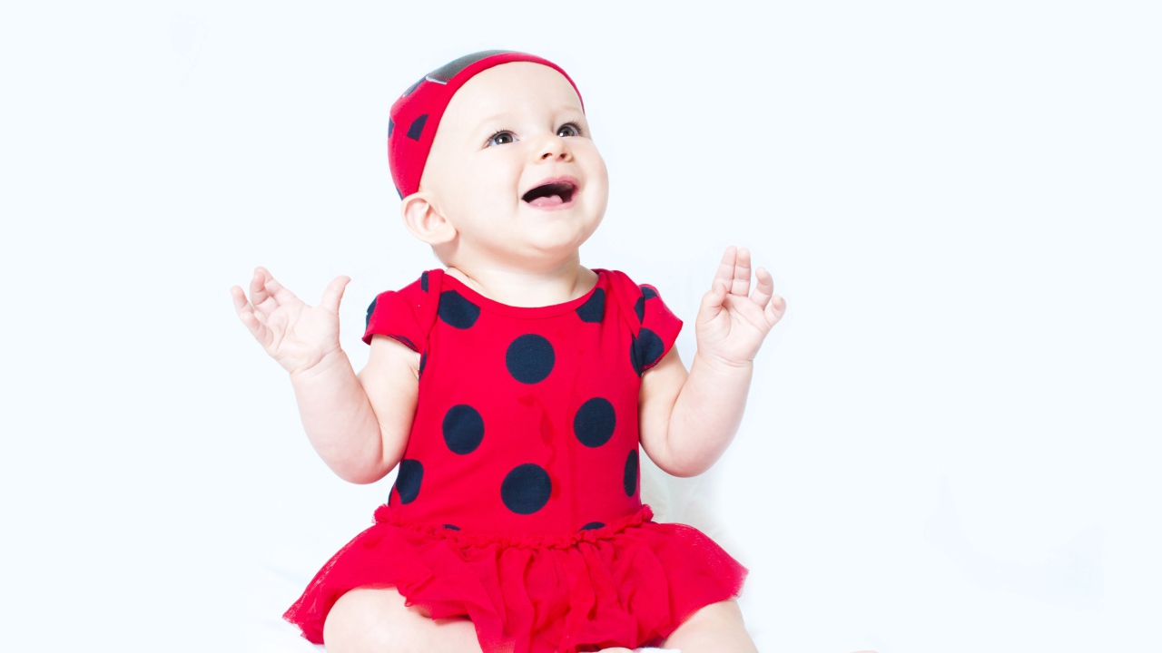 Улыбающаяся девочка в красном платье с черными кругами