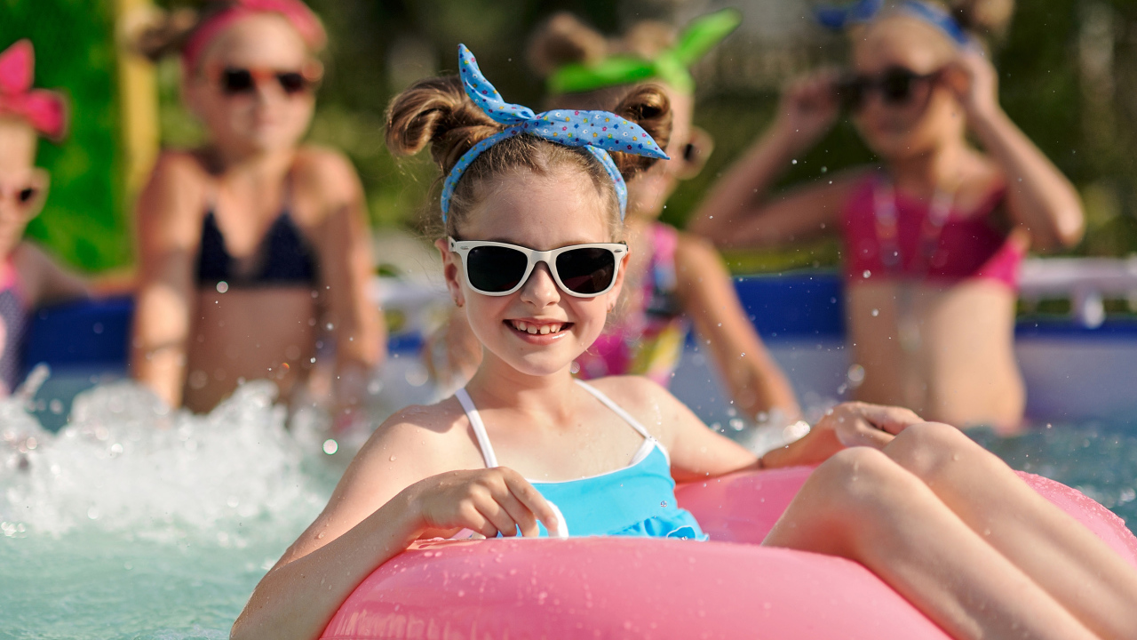 Улыбающаяся девочка со спасательным кругом в бассейне 