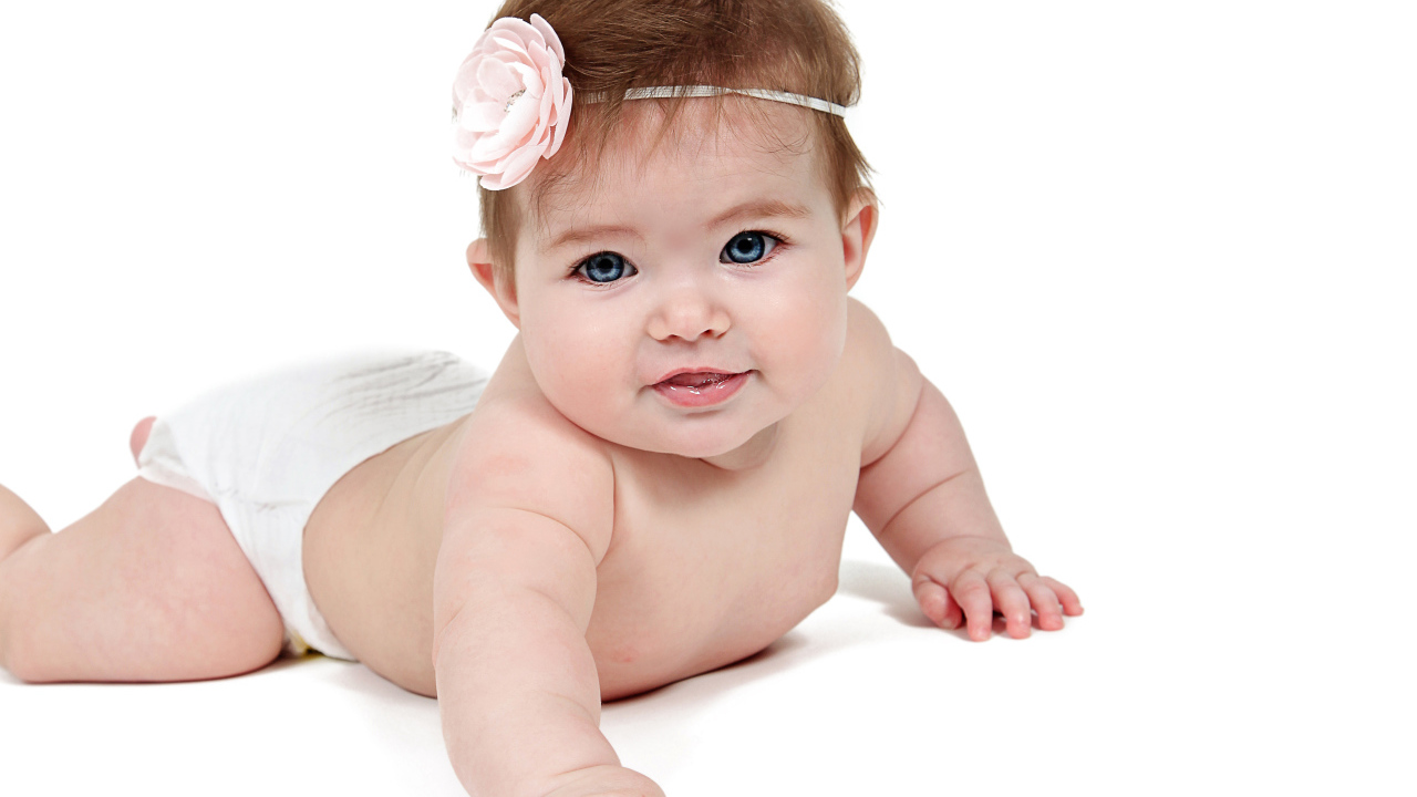 Улыбающаяся маленькая голубоглазая малышка на белом фоне 