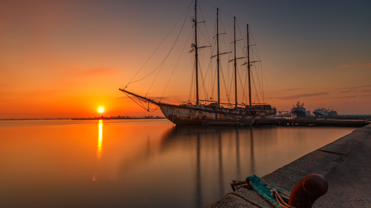 Большой корабль стоит на закате солнца 