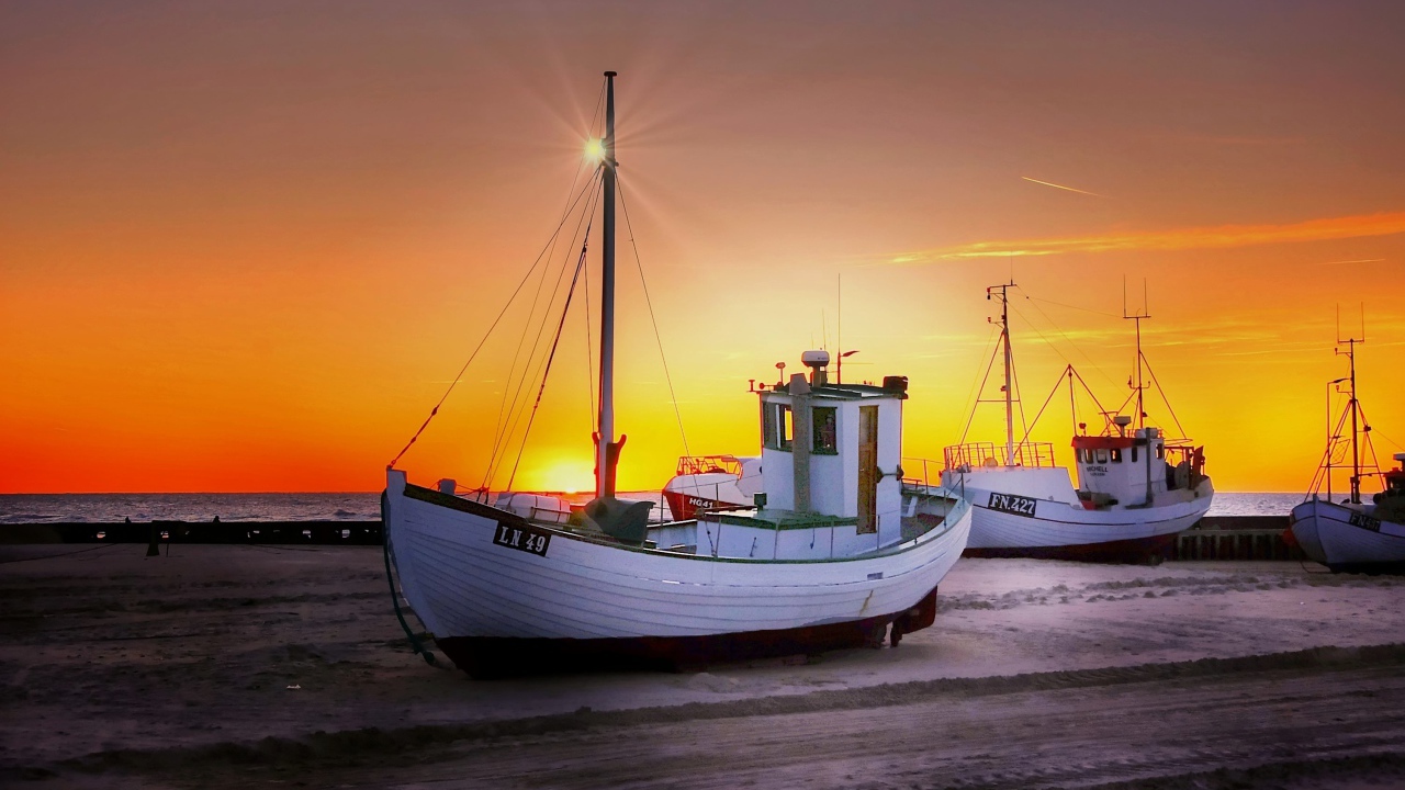 Рыбацкая лодка на берегу на закате 