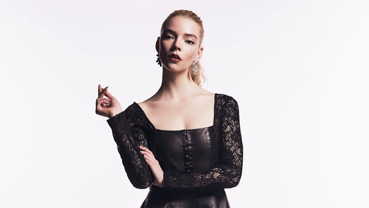 Актриса Аня Тейлор-Джой в черном наряде на белом фоне